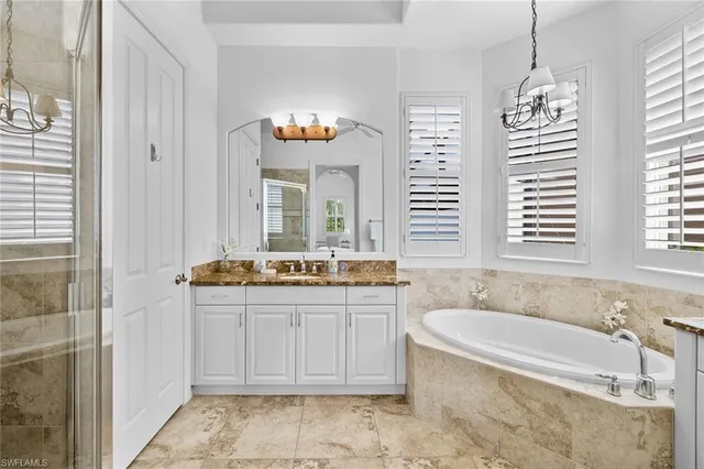 a spacious bathroom with a tub a sink and mirror