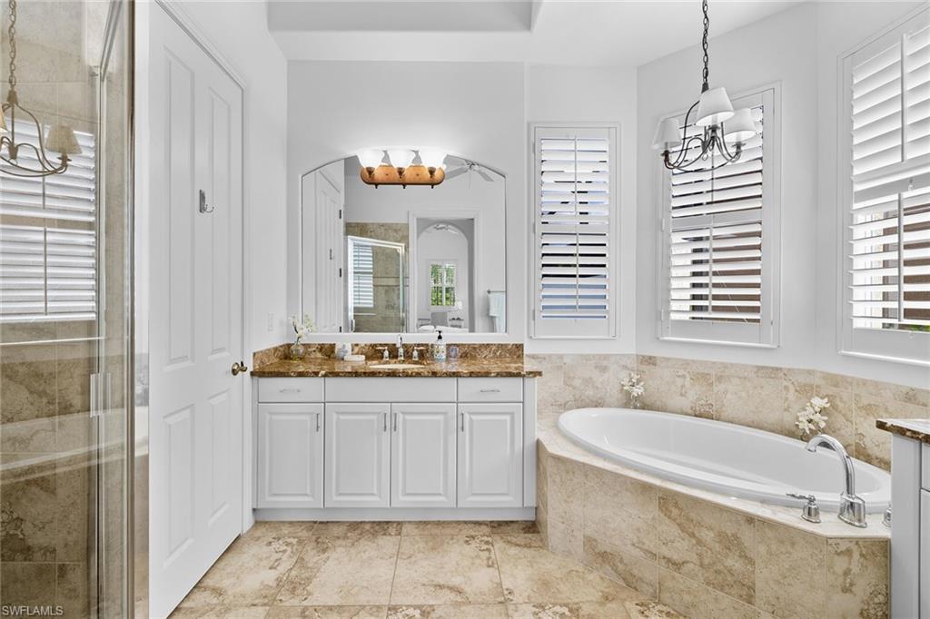 7785 Ashton Road Naples, FL 34113 - Photo 17 of 39 a spacious bathroom with a tub a sink and mirror