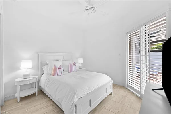 a bedroom with a bed and a large window