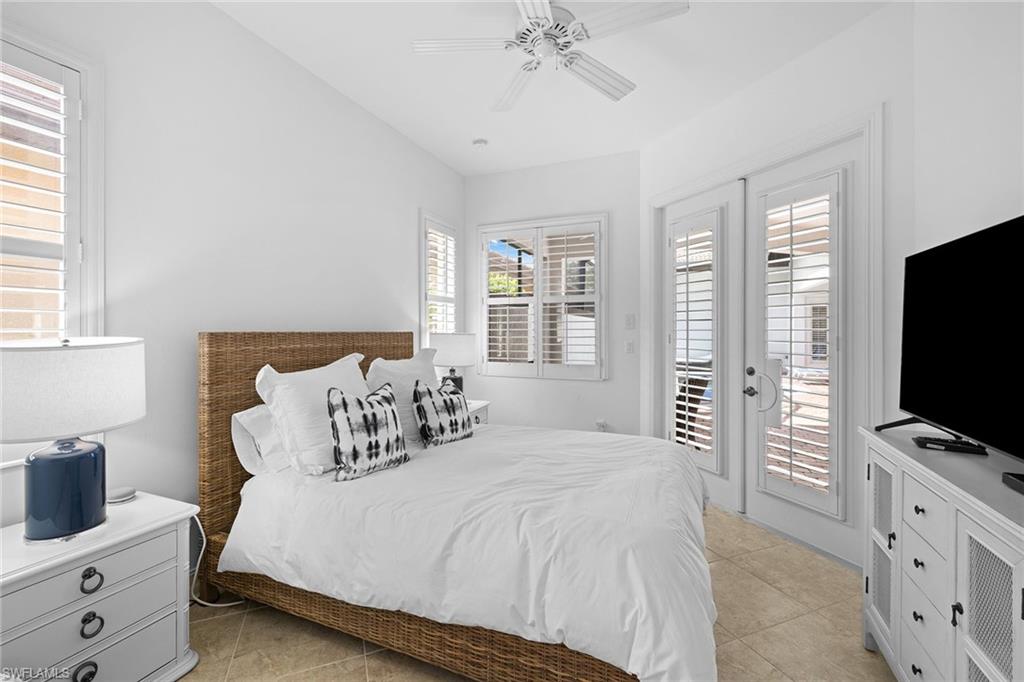 7785 Ashton Road Naples, FL 34113 - Photo 22 of 39 a bedroom with a bed and a flat screen tv