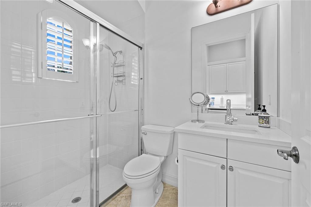 7785 Ashton Road Naples, FL 34113 - Photo 24 of 39 a bathroom with a shower a sink a toilet and a mirror