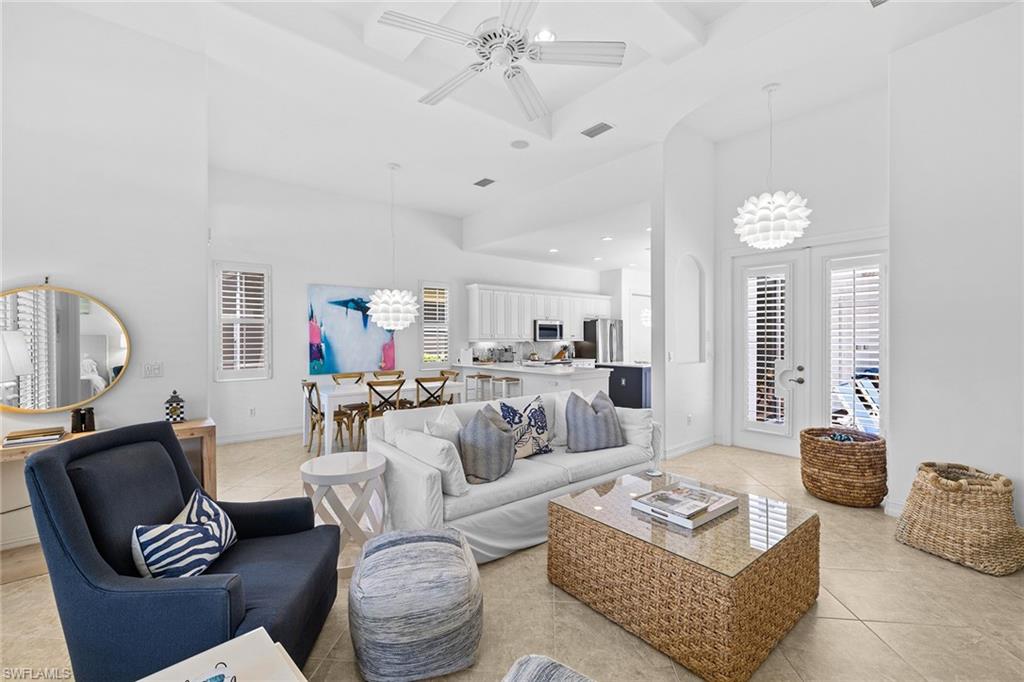 7785 Ashton Road Naples, FL 34113 - Photo 6 of 39 a living room with furniture a rug and a chandelier