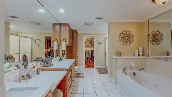 a spacious bathroom with a double vanity sink a mirror and a