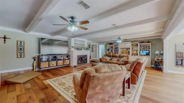 a living room with furniture a flat screen tv and a ceiling fan