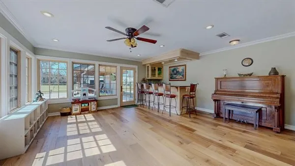 a living room with furniture a flat screen tv and a floor to ceiling window