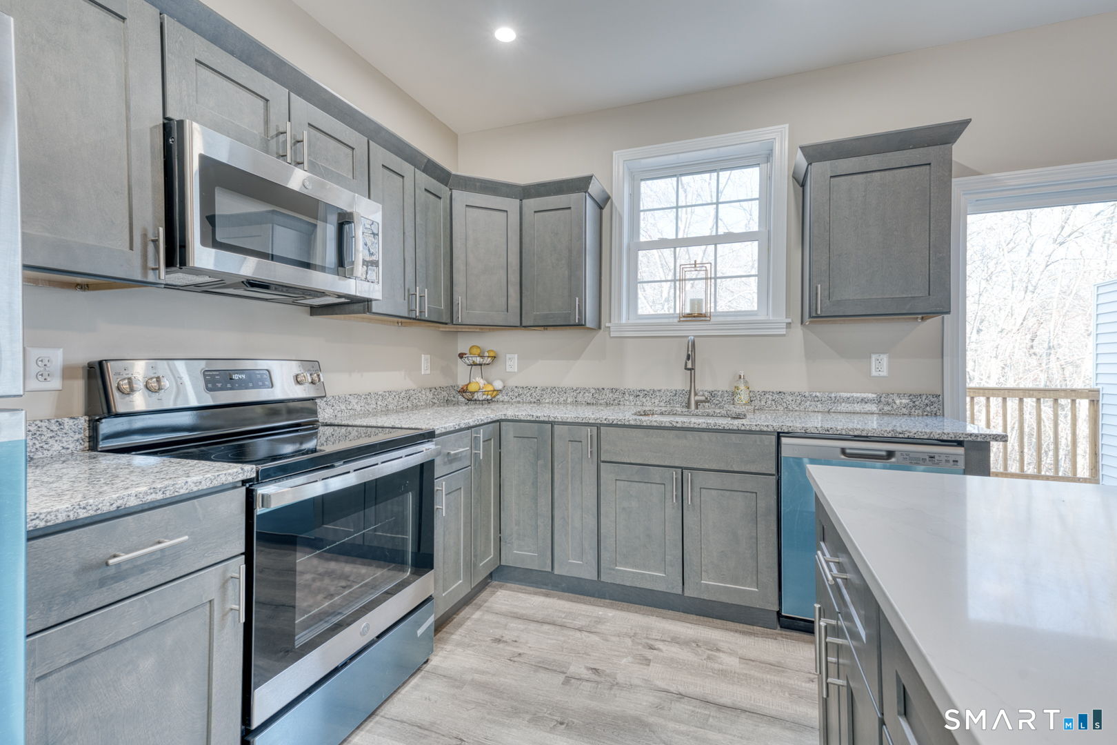 205 Winding Hollow Road Groton, CT 06340 - Photo 7 of 27 a kitchen with stainless steel appliances granite countertop a stove a sink and a microwave