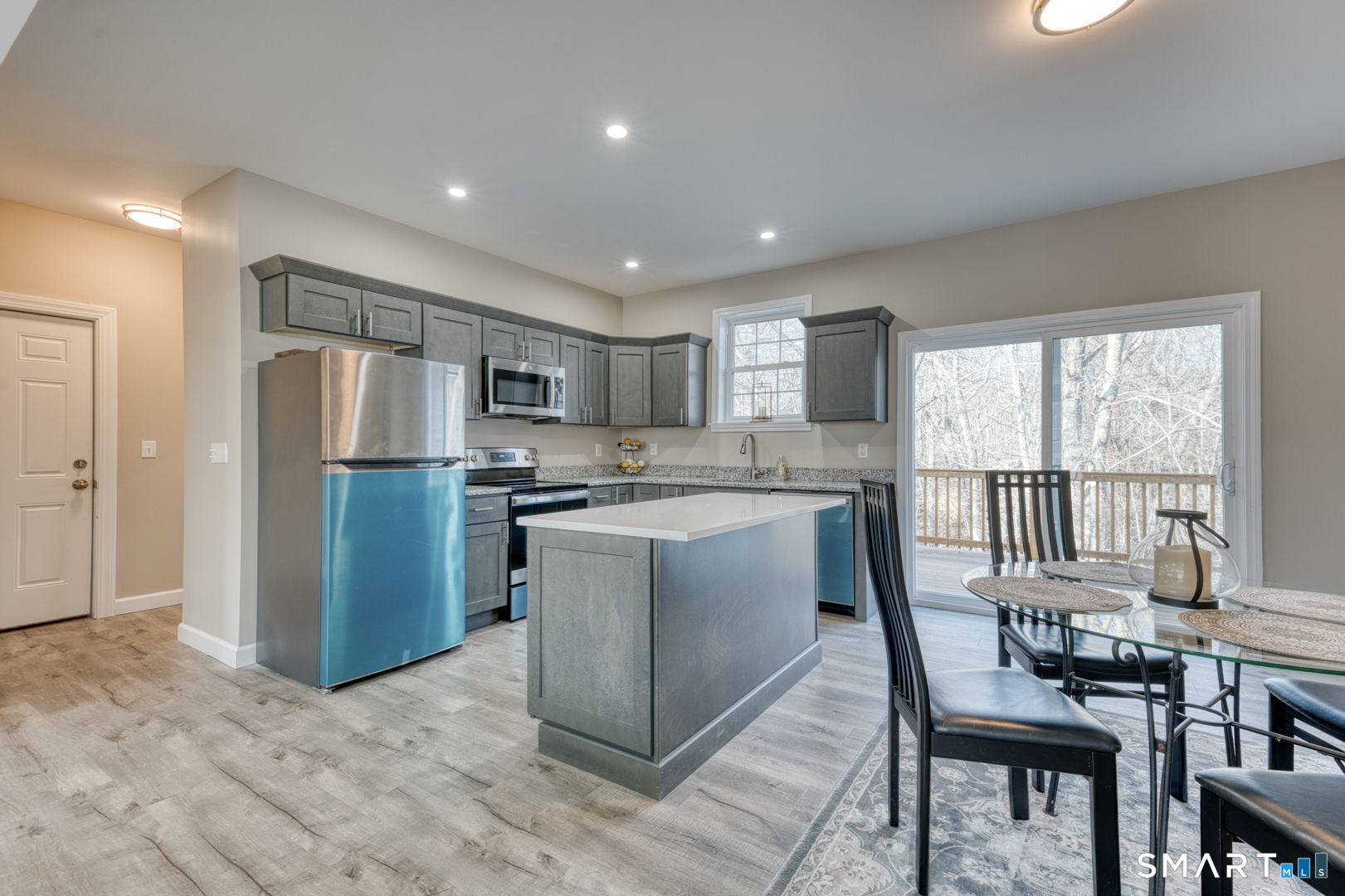 205 Winding Hollow Road Groton, CT 06340 - Photo 9 of 27 a kitchen with refrigerator cabinets dining table and chairs