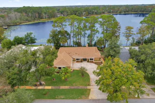 an aerial view of a house with a yard and lake view