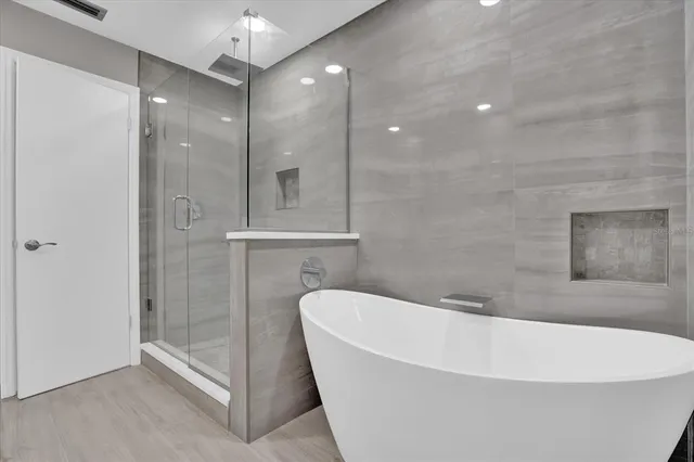 a white bath tub sitting in a bathroom and shower