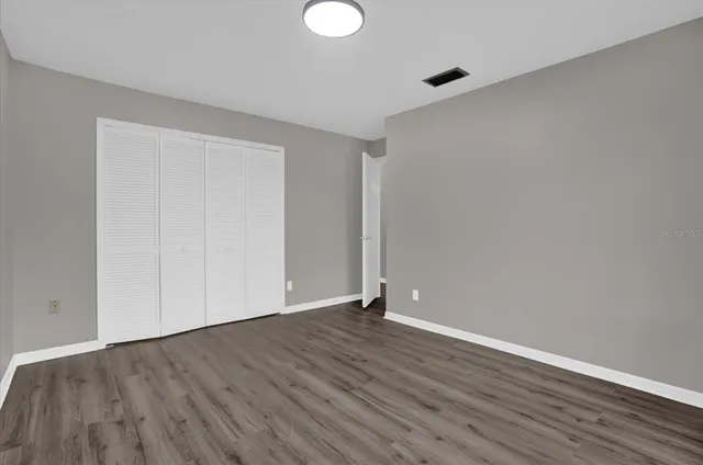 a view of an empty room with wooden floor