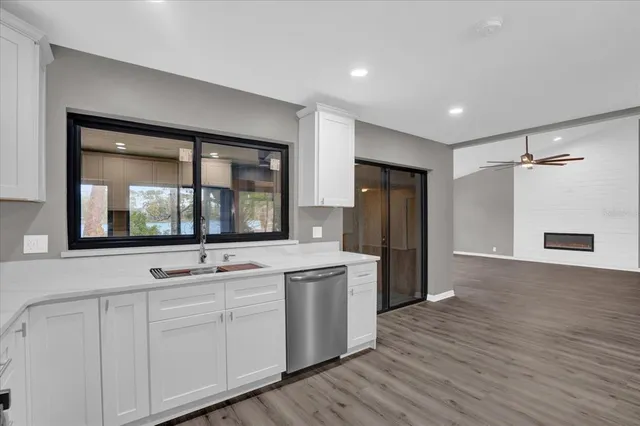 a kitchen with white cabinets and wooden floor
