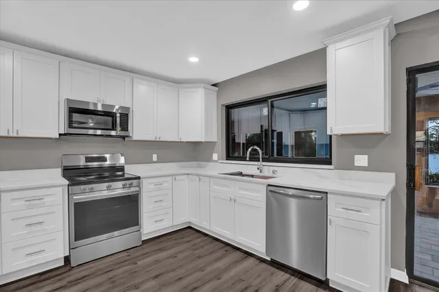 a kitchen with sink a microwave and cabinets