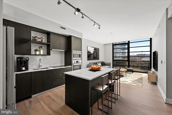 a kitchen with a table chairs and wooden floor