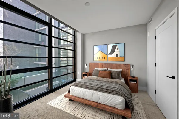 a bedroom with a bed and painting on the wall
