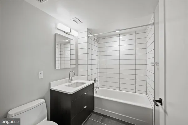 a bathroom with a sink mirror toilet and bathtub