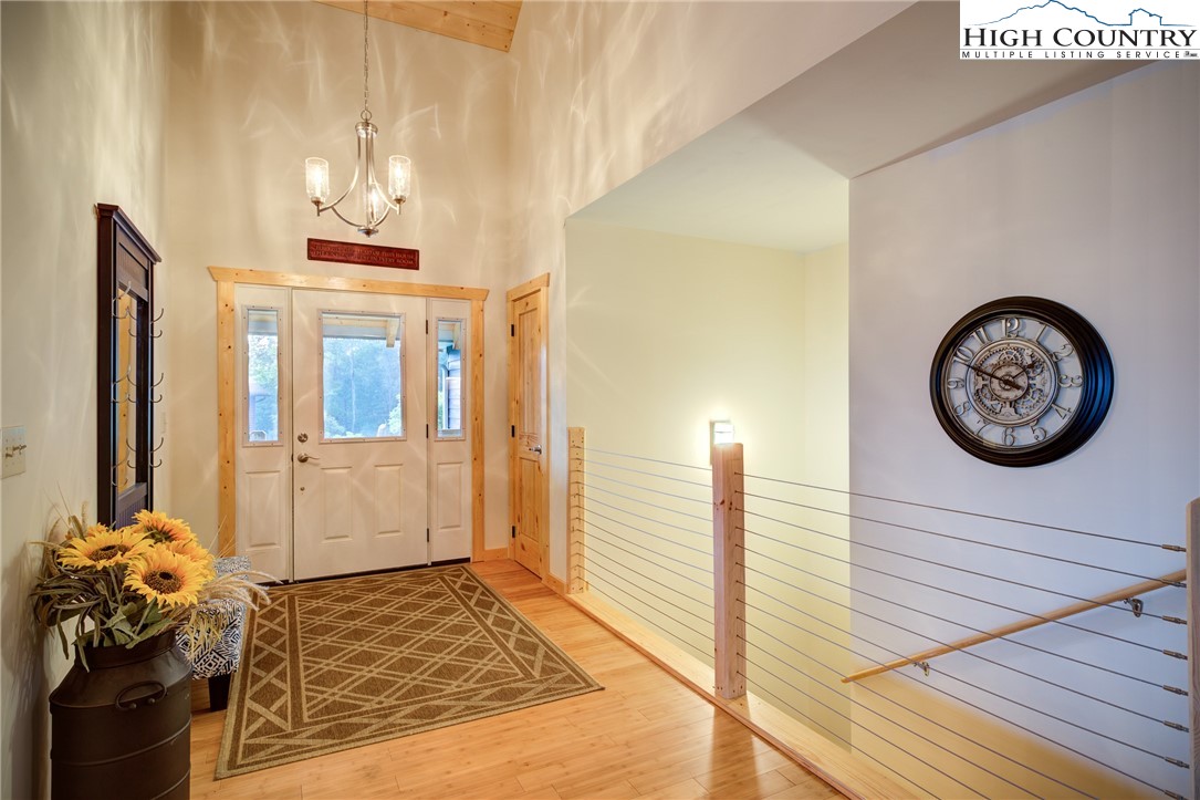 111 Boca Ridge Road Boone, NC 28607 - Photo 12 of 44 a bedroom with a bed and a chandelier