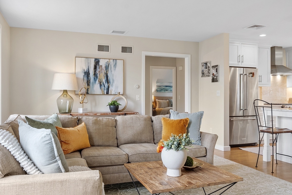 3 B Pelham Road Lexington, MA 02421 - Photo 13 of 41 a living room with furniture white walls and a dining table with kitchen view