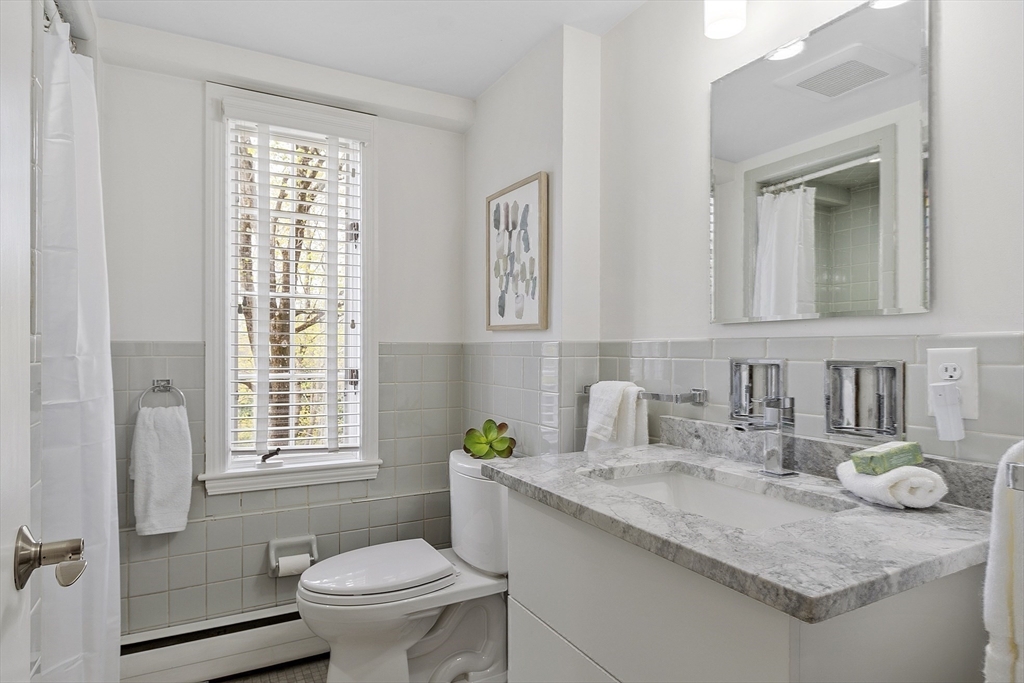 3 B Pelham Road Lexington, MA 02421 - Photo 27 of 41 a bathroom with a granite countertop sink toilet and mirror