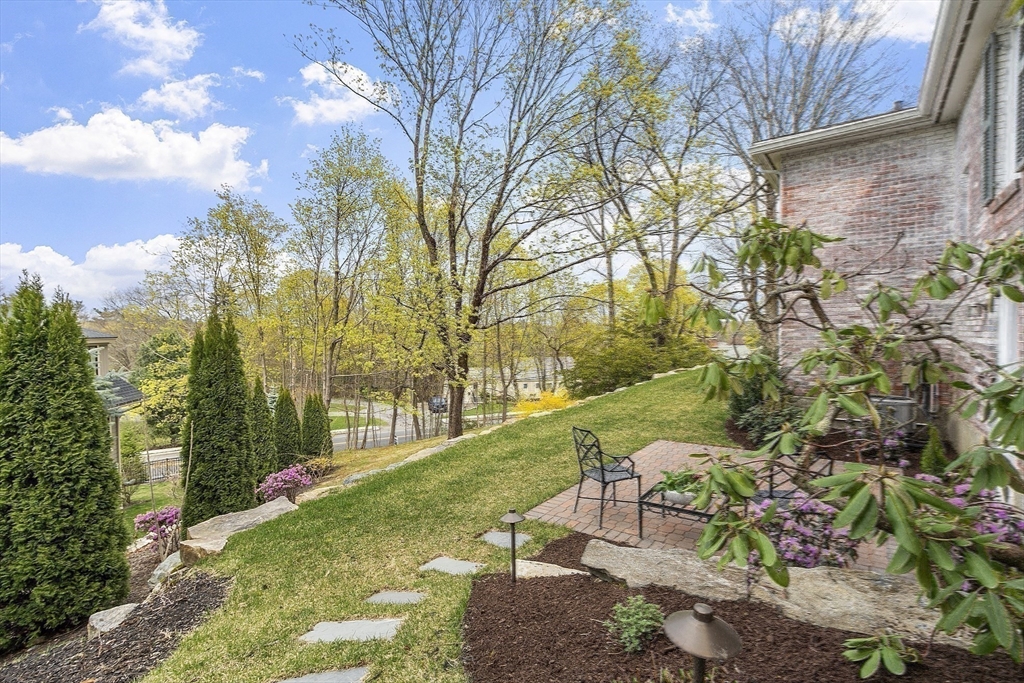 3 B Pelham Road Lexington, MA 02421 - Photo 33 of 41 a view of a garden with a bench