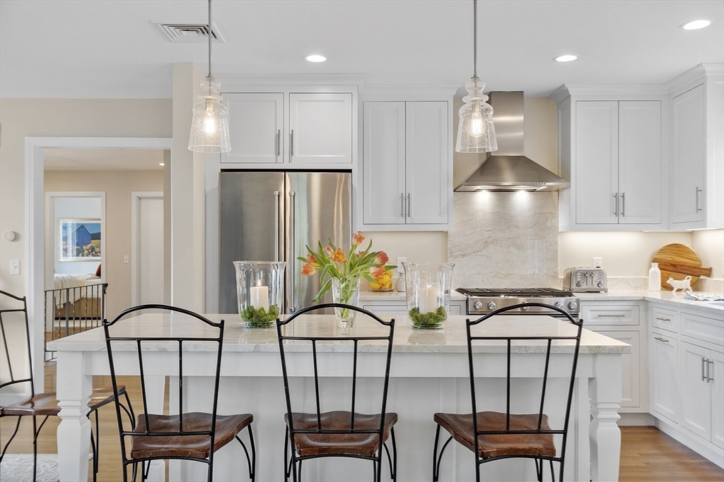3 B Pelham Road Lexington, MA 02421 - Photo 4 of 41 a kitchen with stainless steel appliances granite countertop a table chairs in it and wooden floors