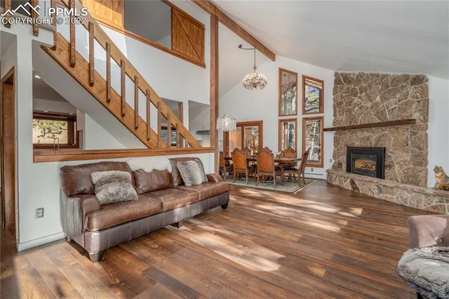 a living room with furniture a fireplace and a large window