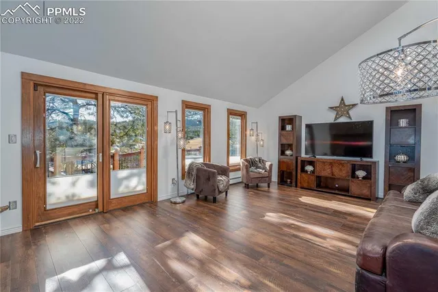 a living room with furniture a flat screen tv and a large window