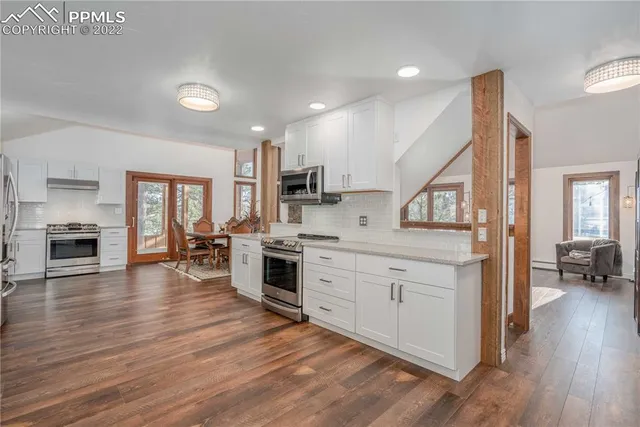 a kitchen with white cabinets and stainless steel appliances