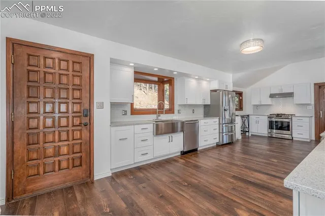 a kitchen with stainless steel appliances a refrigerator and a stove top oven