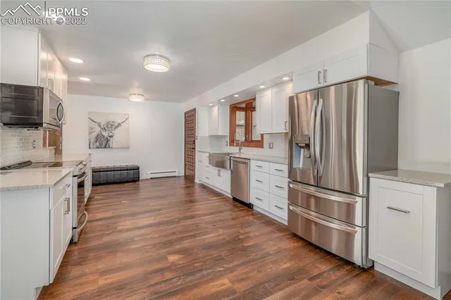 a kitchen with stainless steel appliances granite countertop a refrigerator a stove a sink and a microwave