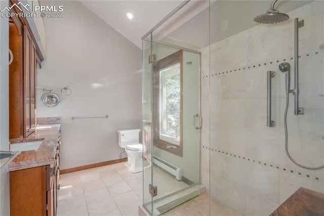a bathroom with a granite countertop sink a mirror and shower