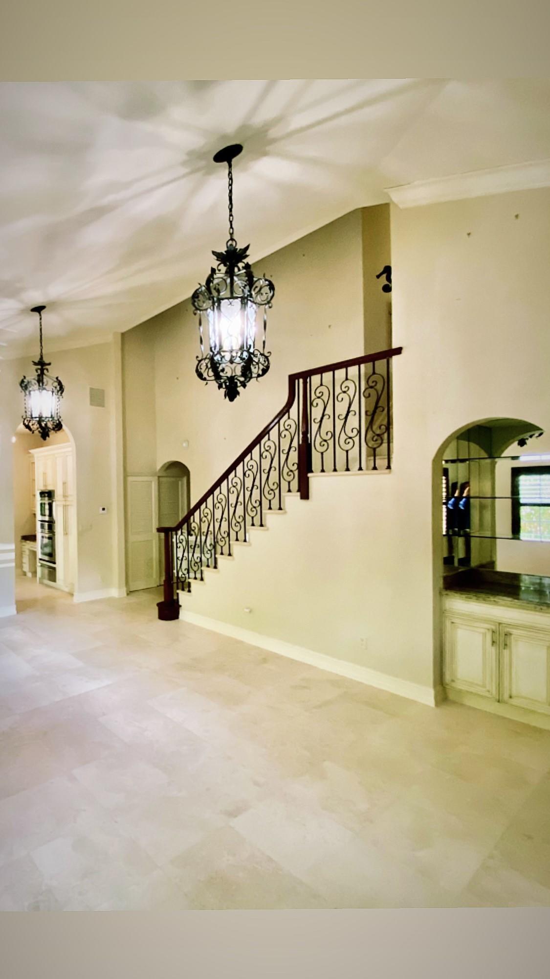 309 Valencia Road West Palm Beach, FL 33401 - Photo 4 of 24 a view of a livingroom with a staircase a fireplace and a chandelier