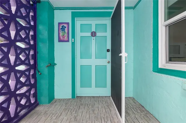 a view of a hallway with wooden floor and a wooden door