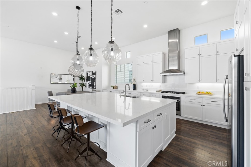 134 Stellar Irvine, CA 92618 - Photo 12 of 49 a large white kitchen with a sink a stove and a wooden floor