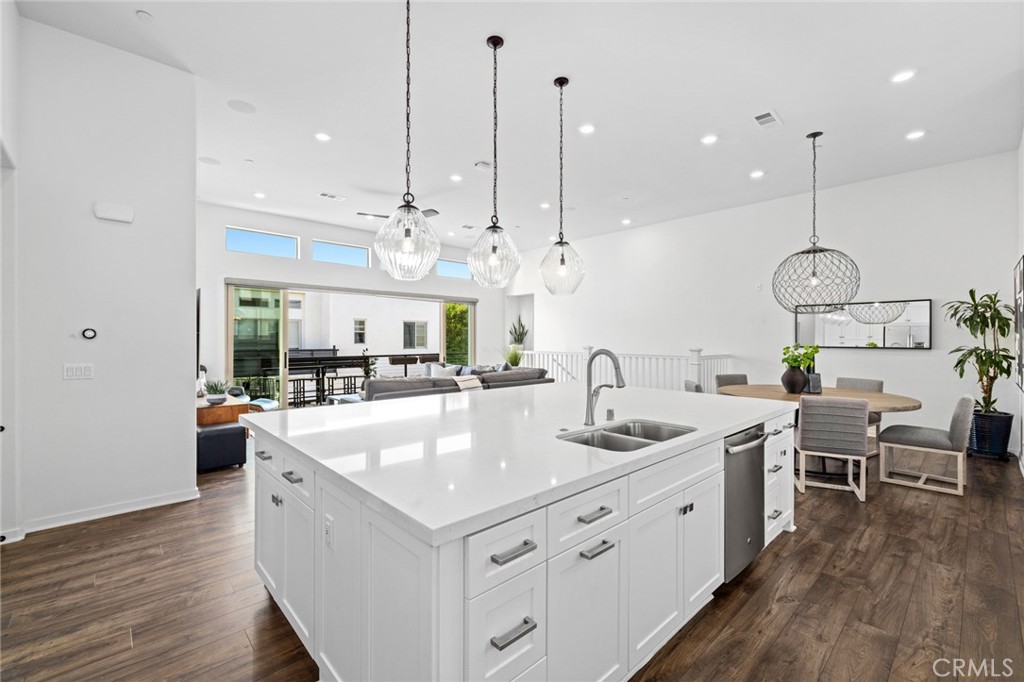 134 Stellar Irvine, CA 92618 - Photo 13 of 49 a large kitchen with kitchen island a large island a sink a stove and a wooden floor