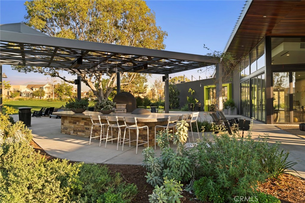 134 Stellar Irvine, CA 92618 - Photo 29 of 49 a view of a patio with table and chairs potted plants and large tree