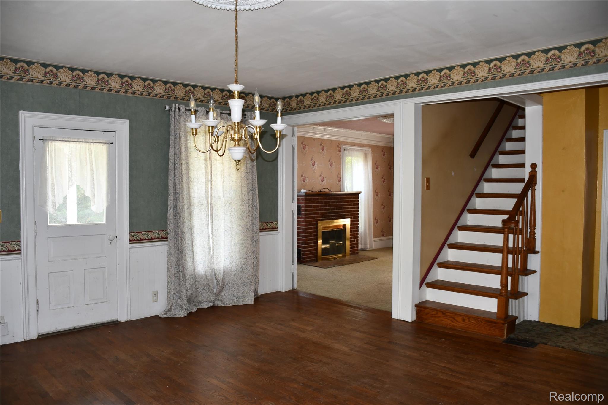 5245 East Clyde Road Howell, MI 48855 - Photo 10 of 28 Welcoming foyer with wood-finish flooring, decorative crown molding, and a brass chandelier