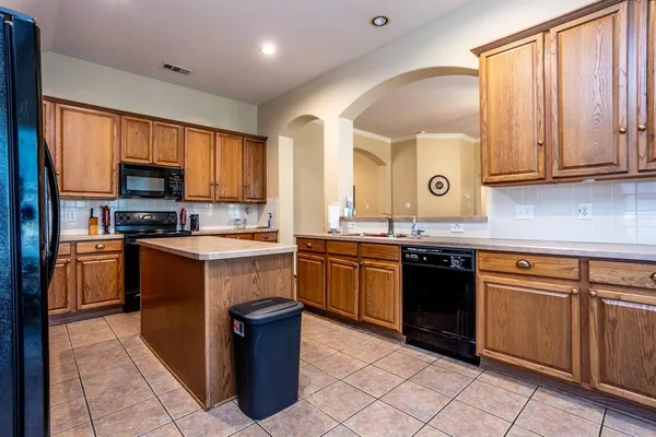 a kitchen with granite countertop a stove top oven microwave and cabinets