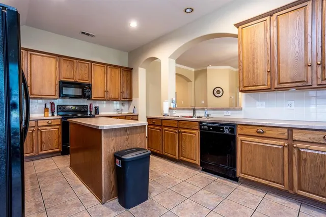 a kitchen with granite countertop a stove top oven microwave and cabinets
