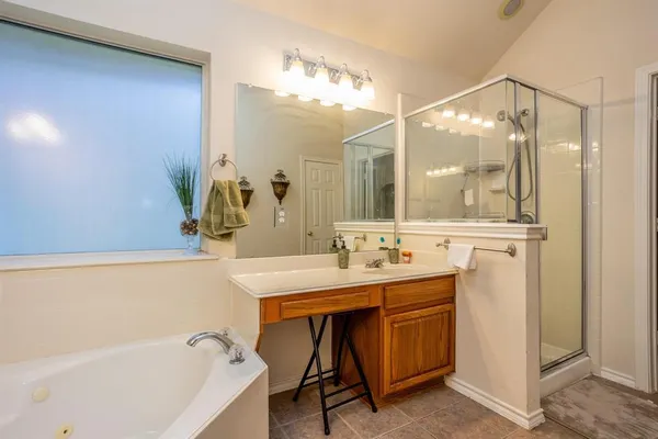 a spacious bathroom with a tub sink and mirror