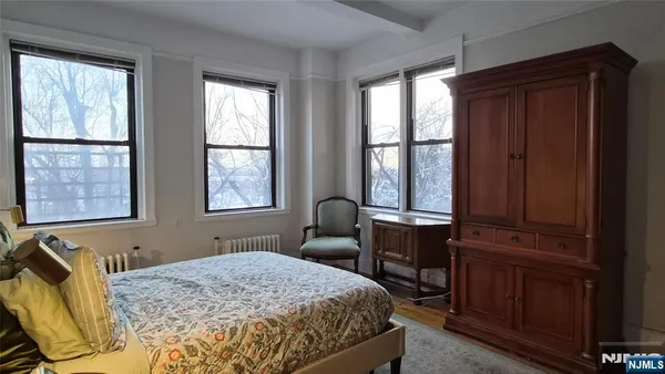 a bedroom with a bed and large windows