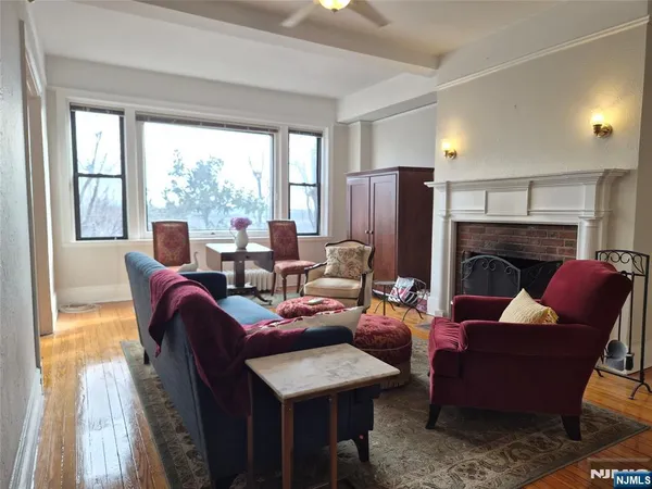 a living room with furniture fireplace and a large window