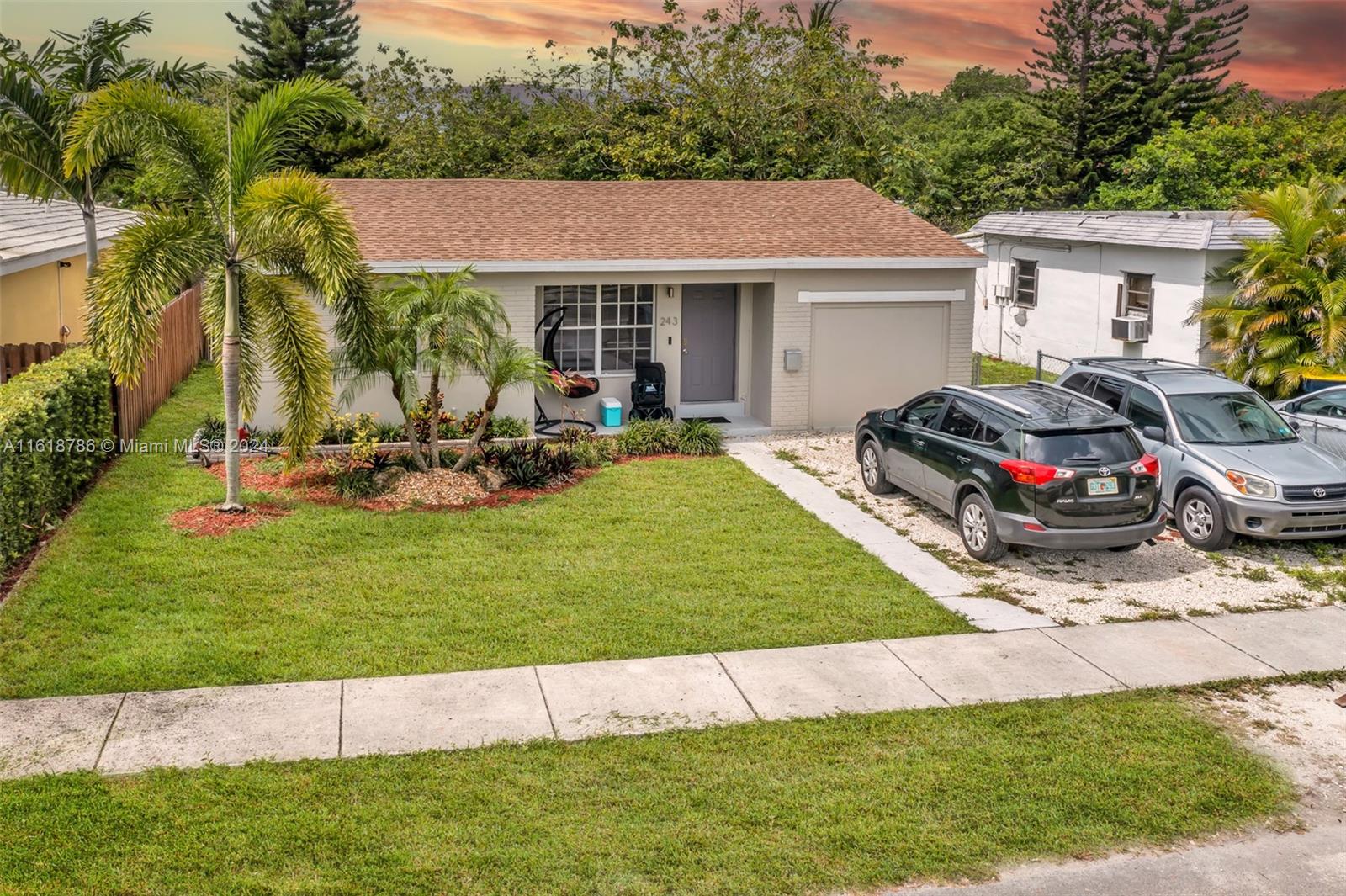 a front view of a house with a garden and yard