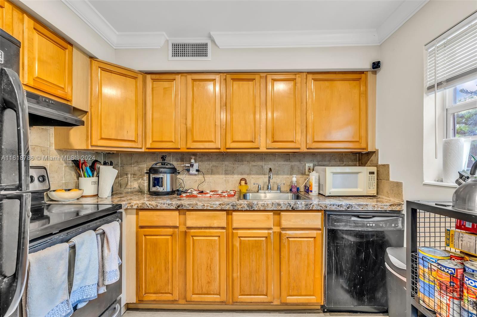 243 Southwest 9th Street Dania Beach, FL 33004 - Photo 24 of 31 a kitchen with stainless steel appliances granite countertop a stove a sink dishwasher and cabinets with wooden floor