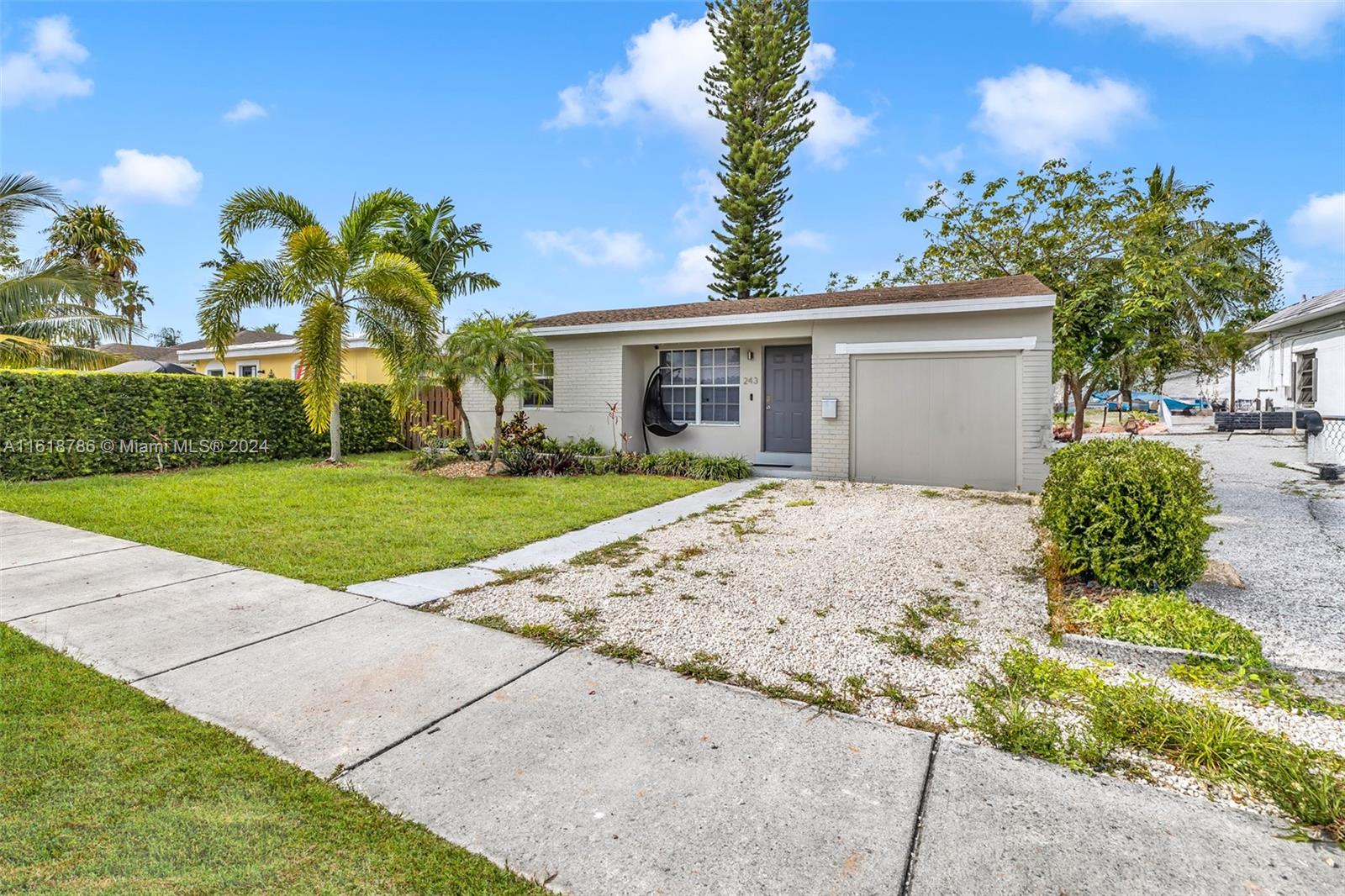 243 Southwest 9th Street Dania Beach, FL 33004 - Photo 9 of 31 a view of a white house with a yard and potted plants
