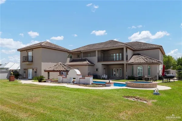 a view of a house with swimming pool and a yard