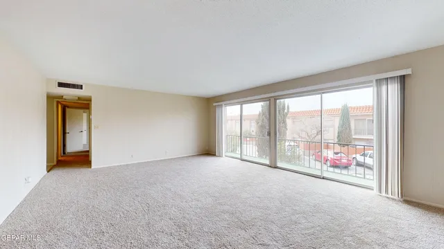 a view of an empty room with a window and a chandelier