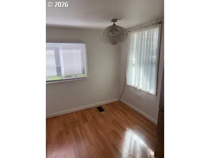 a view of empty room with wooden floor