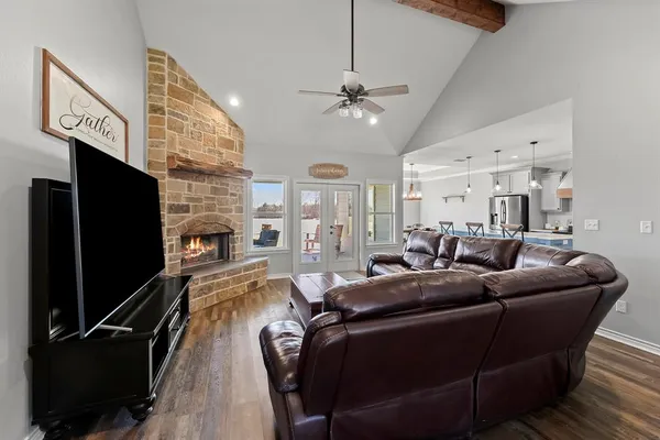 a living room with furniture a ceiling fan and a flat screen tv