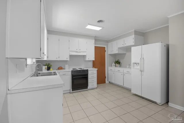 a kitchen with white cabinets and white appliances