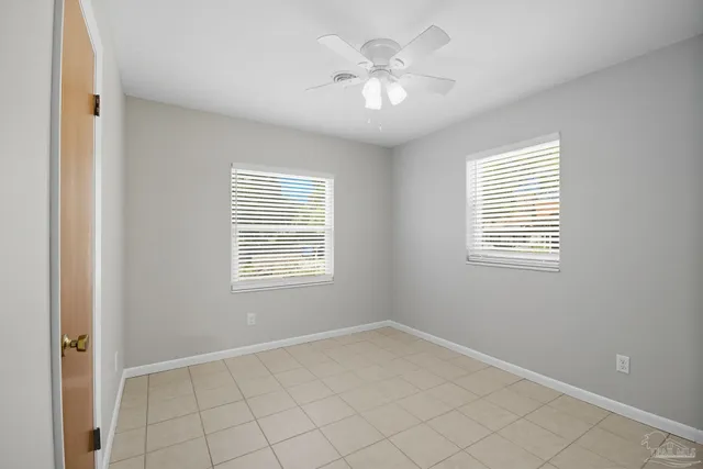 an empty room with chandelier fan